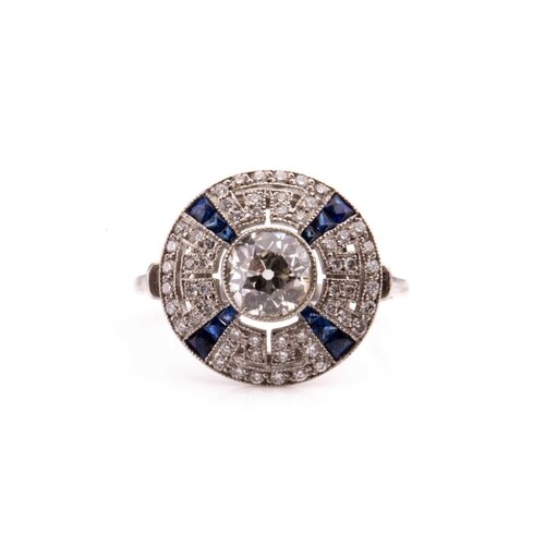 A diamond and sapphire target style circular cluster ring, i...