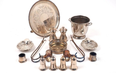 A group of silver plate comprising: a small ice bucket, 12.5cm high; two wine pourers; a bottle coaster, 11.3cm dia.; two shell-shaped dishes; a pierced waiter, 25.7cm dia., a pair of pepper mills by the Peugeot Freres; two pairs of salt and pepper...