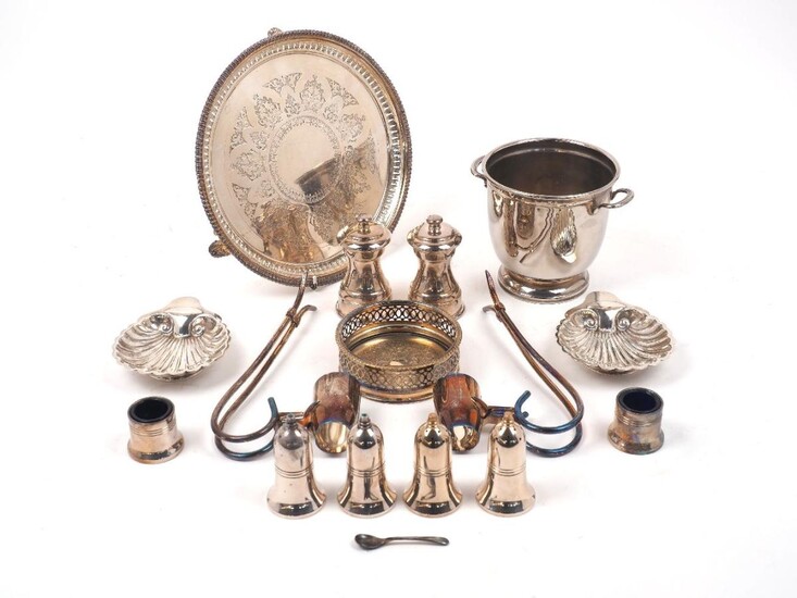 A group of silver plate comprising: a small ice bucket, 12.5cm high; two wine pourers; a bottle coaster, 11.3cm dia.; two shell-shaped dishes; a pierced waiter, 25.7cm dia., a pair of pepper mills by the Peugeot Freres; two pairs of salt and pepper...