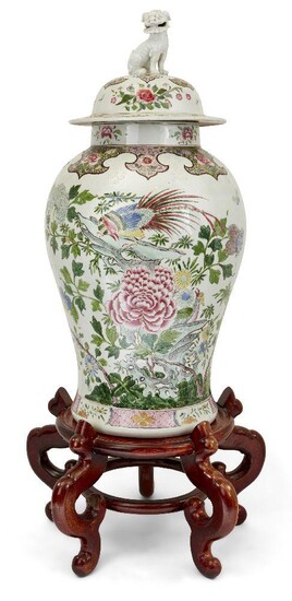 A large Chinese export style baluster form vase and cover, possibly Samson, 20th century, decorated to the body with flora and fauna, the cover with Dog of Fo finial, on carved hardwood stand, 112cm high overall