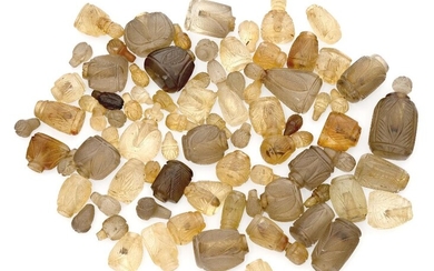 A large quantity of carved citrine and coloured glass miniature scent bottles, most with tops deficient, lengths range from 4.4cm to 1.7cm, carved in the Indian style (a lot)