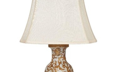 A modern Chinoiserie gilt heightened porcelain vase lamp, decorated overall with scrolling foliate motifs, on a hardwood base, 34cm high excluding shade It is the buyer's responsibility to ensure that electrical items are professionally rewired for...