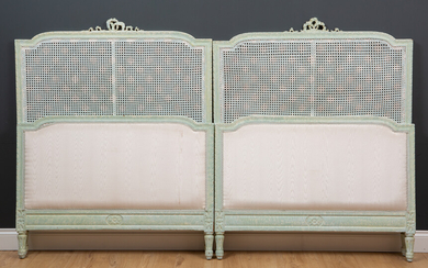 A pair of green painted single beds