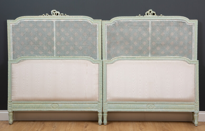 A pair of green painted single beds