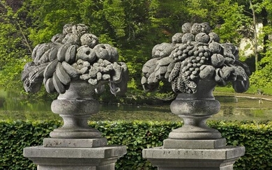 A pair of sculpted limestone pier finials modelled as vases of fruit