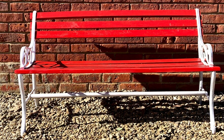 A red painted wooden and cast iron garden bench