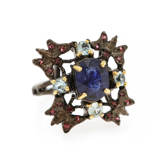 A sapphire, garnet and topaz ring set with an oval cut sapphire and numerous circular-cut garnets and topazes, mounted in gold- and black rhodium plated silver.