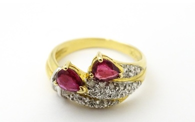 An 18ct gold ruby and diamond ring set with two rubies and a...