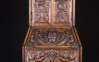 An Unusual 19th Century Carved Oak Fall-front Bureau/Cabinet on Stand. The cabinet having splayed si