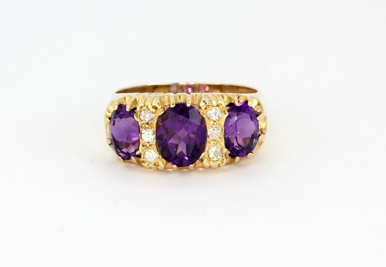 An antique hallmarked 9ct yellow gold ring set with three large oval cut amethysts and diamonds, (Q).