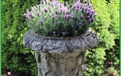 An artificial stone garden planter with ornaments. H. 55 cm. Diam. top 45 cm.