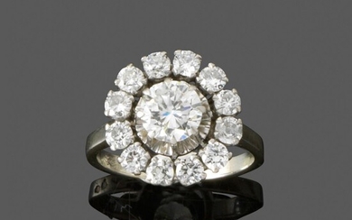 Bague diamants En platine et or gris, ornée au centre d'un diamant taille brillant entouré...