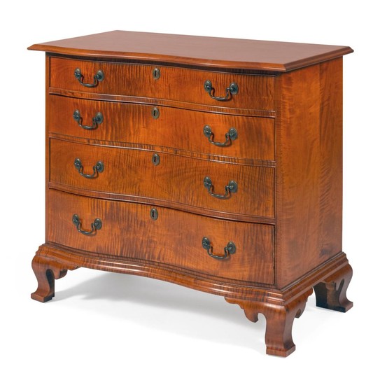 ELDRED WHEELER SERPENTINE-FRONT CHEST OF DRAWERS In tiger maple, with four graduated drawers and an ogee bracket base. Drawers with...