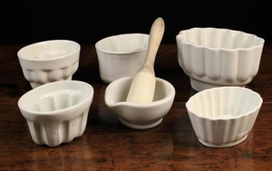 Five White Glazed Pottery Jelly Moulds & a white ceramic pestle & mortar; the pestle with turned wooden handle.