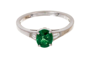 Green diopside and diamond ring with an oval green diopside measuring approximately 6.8 x 5.6mm flanked by tapered baguette cut diamonds to the shoulders on platinum shank, ring size N½.