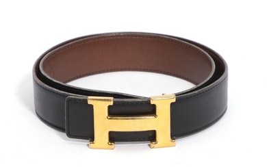 Hermès A belt of black and dark brown leather with gold toned...