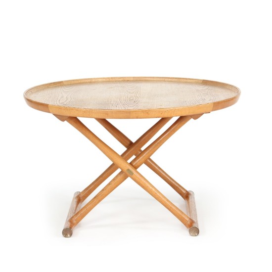 Mogens Lassen: “The Egyptian Table”. Circular coffee table of patinated oak mounted on cross-legged, foldable frame with brass fittings.