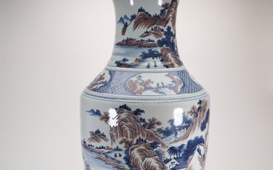 a large blue and white vase with underglaze red landscape and figures