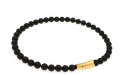 1927/1139 - Ole Lynggaard: A diamond clasp set with a brilliant-cut diamond, totalling app. 0.08 ct., mounted in 18k gold and white gold. And an onyx necklace. (2)