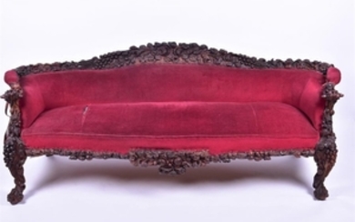 A 19th century European rosewood sofa the low back and frame with detailed carved fruit and leaves, plush red upholstered...