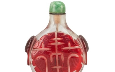 CHINESE OVERLAY GLASS SNUFF BOTTLE In flattened ovoid form, with red dragon fret and mask handles on a clear ground. Height 2.2". Ja...