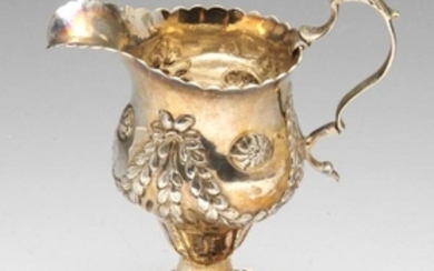 An early George III silver cream jug, the bulbous form