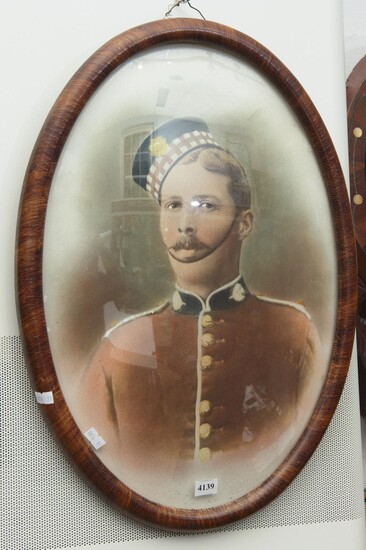 A 1900S OVAL FRAMED HAND TOUCHED PHOTO OF A SCOTTS GUARD WITH CONVEX GLASS 52 X 37CM