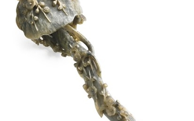 A Chinese Ruyi scepter of greenish jade richly carved with prunus in blossom. Late Qing, 1900. Weight 746 g. L. 38 cm.