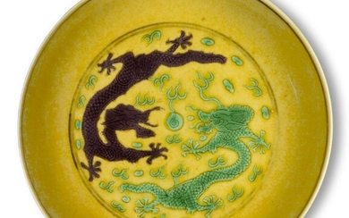 A Chinese imperial porcelain saucer dish, Guangxu mark and of the period, painted on a yellow ground and incised with a green and aubergine five-clawed dragon encircling a flaming pearl amongst sylised clouds and flames, the underside with...