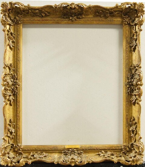A Gilded Composition Louis XV Style Swept and Pierced Frame, late 20th century, with cavetto sight, cushioned stiff leaf, the plain ogee hollow with foliate and flower head scrollwork, shell cartouche centres and corners, plain back edge, 42 x 34.5...
