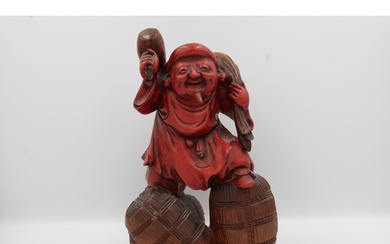 A Japanese figurine, possibly made of wood or hard resin, da...