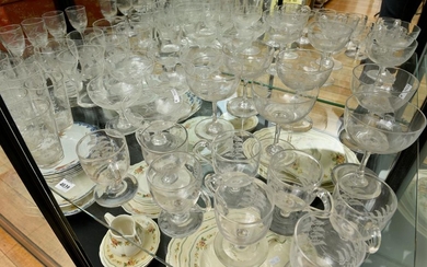 A LARGE COLLECTION OF ETCHED GLASS INCLUDING CUSTARD CUPS AND CHAMPAGNE GLASSES