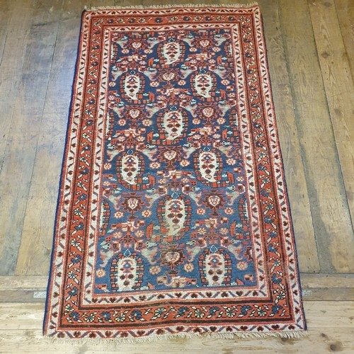 A Persian blue ground rug, with multiple borders, centre wit...