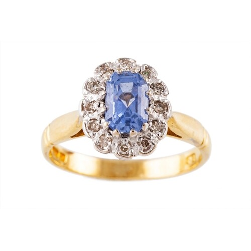 A SAPPHIRE AND DIAMOND CLUSTER RING, of oval form, mounted i...