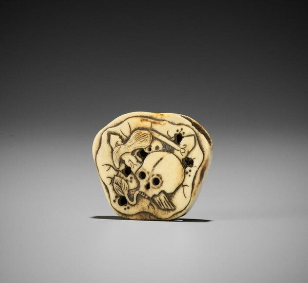 A STAG ANTLER NETSUKE WITH SKULL AND LOTUS