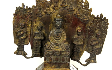 A Tibaten bronze figure flanked by monks with a flamed tankgha style surround, H. 23cm.