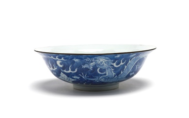 A blue and white porcelain bowl painted with dragon amidst clouds on a blue ground