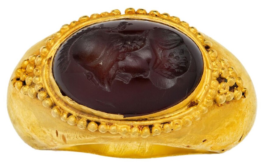 A carnelian intaglio ring, in the Roman style, set with an oval carnelian intaglio depicting the profile of a helmeted warrior, unmarked, ring size S