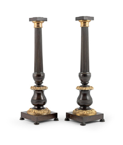 A large pair of French early 20th century patinated and gilt bronze candlesticks