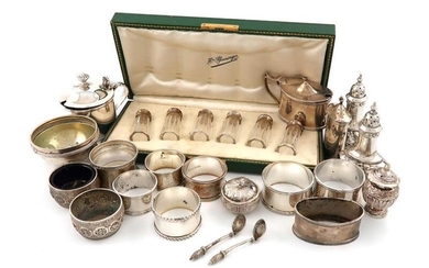 A mixed lot of silver items, comprising: a George III mustard pot, by J. Angell, London 1819, circular form, leaf capped scroll handle, domed cover with a fluted finial, a cased set of six French silver-mounted glass pepper pots, a three-piece...