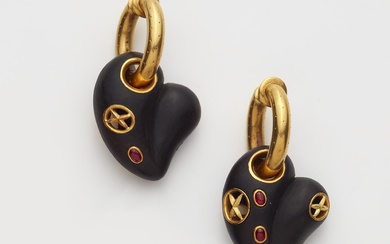 A pair of 18kt gold hoop earrings with ruby set carved ebony heart pendants.