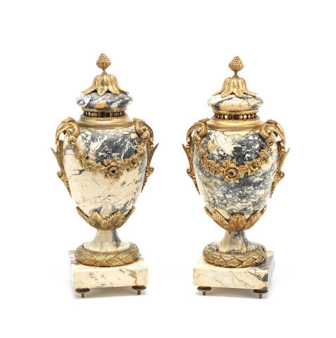 A pair of gilt bronze mounted beige veined marble garniture urns