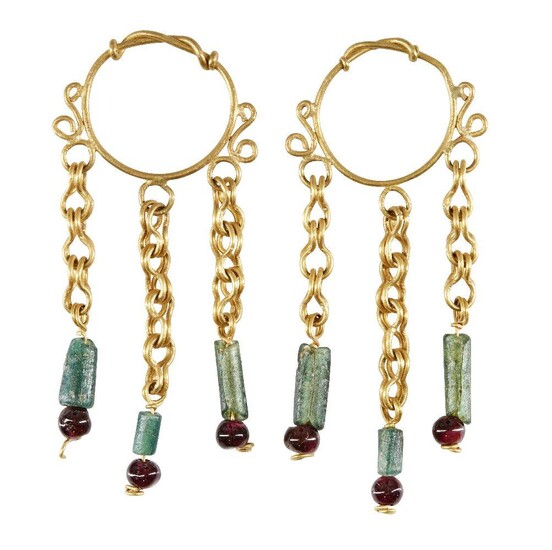 A pair of gold earrings in the Roman style, the hoop with twisted wire detail, each with three gold suspension chains below set with green glass bead and garnet, 6.5cm. long, 13.2 grams (2) Provenance: Private family collection formed in the 1970s