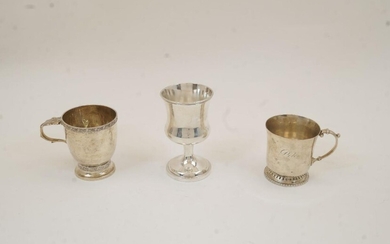 A silver christening cup, Birmingham, 1929, rubbed maker's marks, with scrolling foliate borders and acanthus thumbpiece, on circular foot, 8.5cm high; together with another christening cup, Birmingham, 1934, William Suckling Ltd, with scroll...