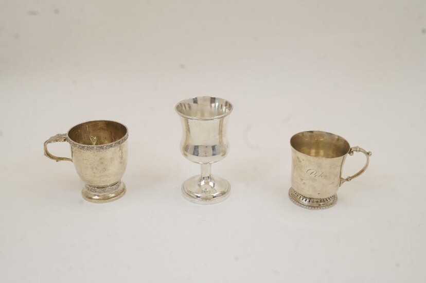 A silver christening cup, Birmingham, 1929, rubbed maker's marks, with scrolling foliate borders and acanthus thumbpiece, on circular foot, 8.5cm high; together with another christening cup, Birmingham, 1934, William Suckling Ltd, with scroll...