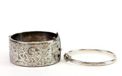 A wide engraved vintage hallmarked silver hinged bangle together with a further bangle.