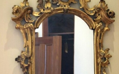 AN ANTIQUE CONTINENTAL GILTWOOD SCROLLING MIRROR with