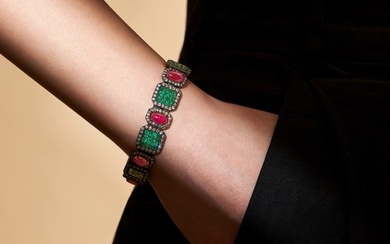 AN EMERALD, RUBY AND DIAMOND BRACELET set with a row of oval cabochon rubies and clusters of squa...