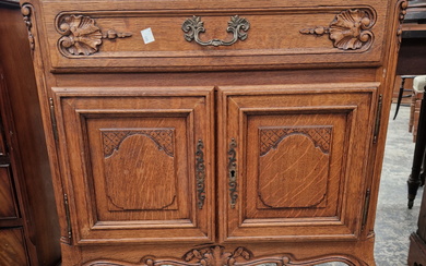 AN OAK SIDE CABINET WITH A DRAWER ABOVE PANELLED DOORS, CABRIOLE FRONT LEGS ON CARVED FEET