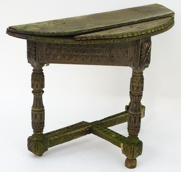 An antique credence table with a demi lune top and